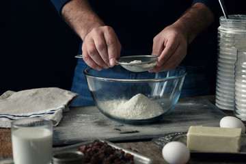 Man cooking cross buns in kitchen. Ingredients cooking cross buns