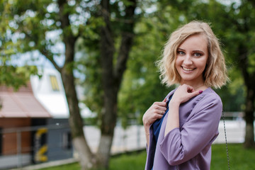 Fototapeta na wymiar Portrait attractive girl with blond hair in a park