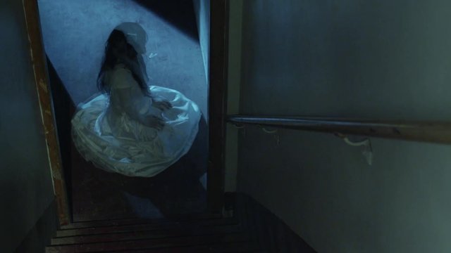 Crazy girl sitting at the bottom of the stairs, rocking back and forth