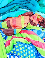 Multi-colored blankets, including the dots, diagonal stripes.