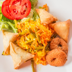assiette créole, achards, samoussas, bonbons piment, salade verte et tomates 