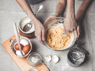 Mothers and children's hands cook dough for home-made cookies. We cook in kitchen together with children. Happy family