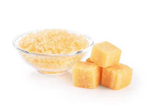 Pieces of parmesan cheese and grated cheese in glass bowl isolated on white background.