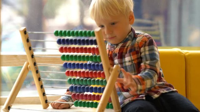 boy in kindergarten playing with abacus
