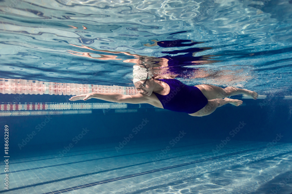 Canvas Prints underwater picture of female swimmer in swimming suit and goggles training in swimming pool