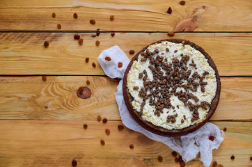 Homemade cheesecake with chocolate on the brown plate decorated with white cloth and raisins. Top view