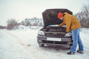 upset young men looking under the hood