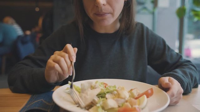 Woman eating caesar salad in a cafe