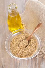 Bottle of flax seed oil ans seeds on wooden table.