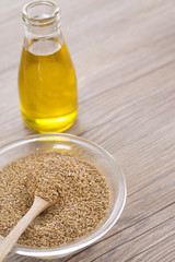 Bottle of flax seed oil ans seeds on wooden table.