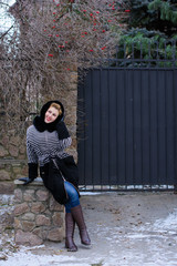 Happy and smiling woman on weekend. Lady in a striped coat walks on the street enjoying fresh air...