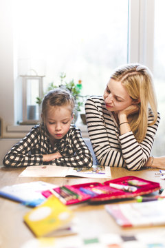 mother and daughter togehter doing schoolwork at home