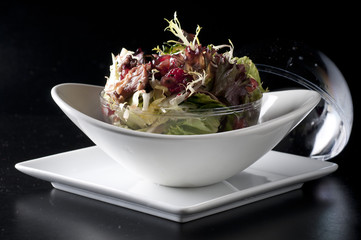 ensalada agitada de confit de pato con granada y vinagreta de hoisin.