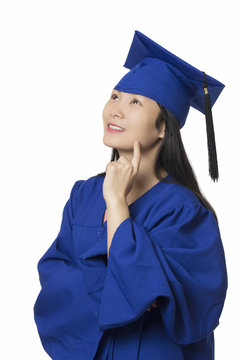 Asian woman deep in thought wearing graduation gown isolated white background