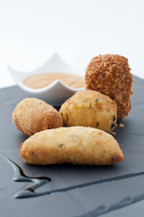 Croquetas  Variadas de calabacín, cocido, bacalao y mejillón con salsa romesco.