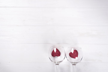 Red hearts in a glasses on wooden background
