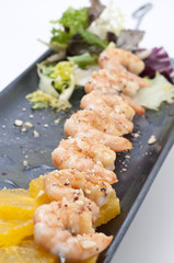 brocheta de langostinos y coco con vinagreta de naranja.