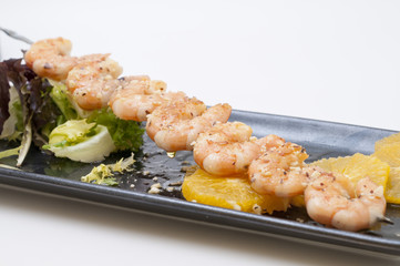 brocheta de langostinos y coco con vinagreta de naranja.