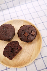 Homemade Chocolate Cupcake and Half One on Wooden Plate 