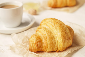 Delicious morning coffee cup with croissant close up on white