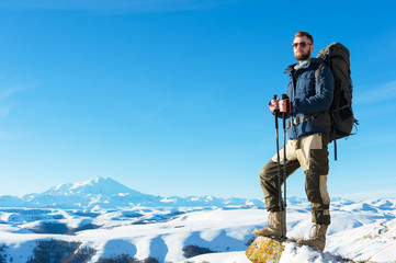 A hipster traveler with a beard wearing sunglasses in nature.