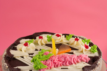Round tasty chocolate cake on pink background