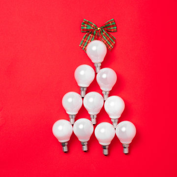 The christmas tree from lantern lamps laying on red background with copy space.