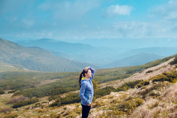 Young fitness woman in sportswear poses at the beautiful mountains