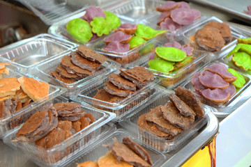Colorful dessert called Pang Ji or Thai small sweet deep fried pancake in plastic box