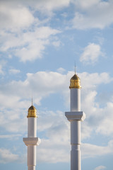 Fototapeta na wymiar Minarets from a mosque against a cloudy sky.