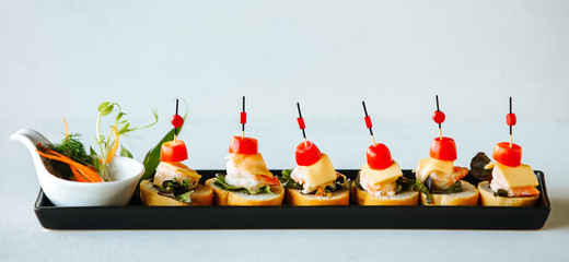 Shrimp cheese and tomatoes on a skewer with bread. Buffet, treats on the table