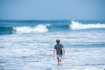 Fototapeta na wymiar Surfing the waves of Indonesia beach