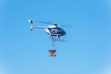 Hubschrauber mit Düngkalk in der Luft.