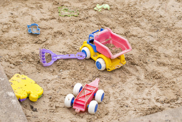 Fototapeta na wymiar Children wooden sand box with some plastic toys
