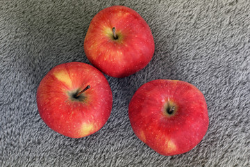 Red apples on wool. Apples on a gray background. Fruit
