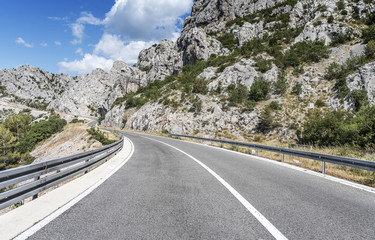 Country road through the rocky mountains and forest.