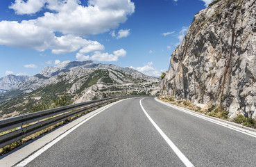 Country road through the rocky mountains and forest.