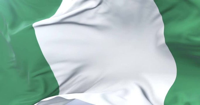 Flag of Nigeria waving at wind in slow in blue sky, loop
