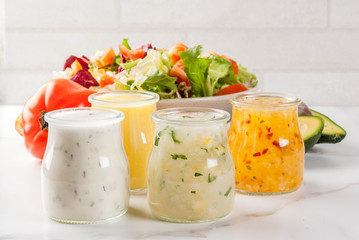 Set of classic salad dressings - honey mustard, ranch, vinaigrette, lemon & olive oil,  on white...