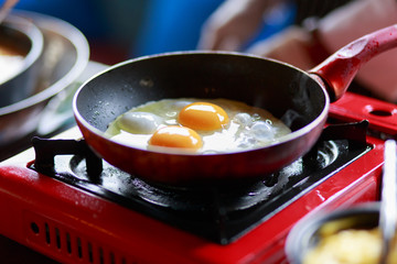 Cooking Eggs Sunny-side-up in a non-stick pan on a gas stove. Frying a batch of eggs for breakfast in a non-stick pan with a gas stove.