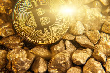Golden shining bitcoin on mound of gold