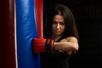 Portrait of woman kicking boxing bag