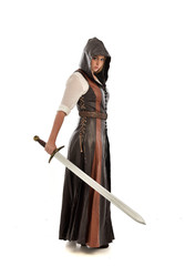 full length portrait of girl wearing brown  fantasy costume, holding a sword. standing pose on...