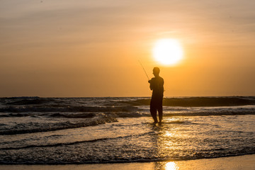 Fototapeta premium Man fishing in the evening at beach
