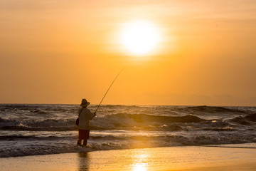 Fototapeta premium Man fishing in the evening at beach
