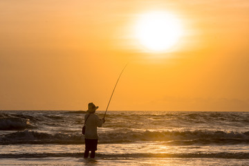 Man fishing in the evening at beach
