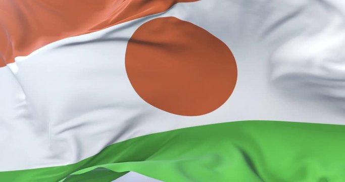 Flag of Niger waving at wind in slow in blue sky, loop