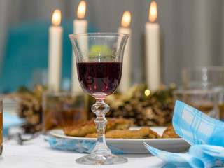 A moody evening, dinner at home, a glass of wine on the table, dishes and candles. Nice background.