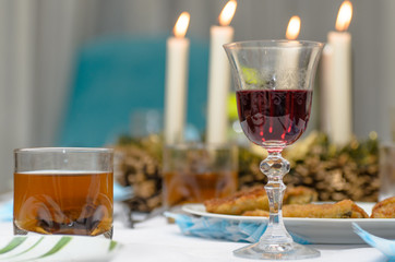 A moody evening, dinner at home, a glass of wine on the table, dishes and candles. Nice background.