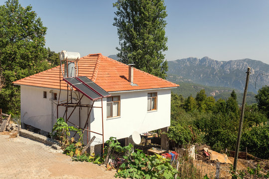 private house with red roof tiles in hot country with solar panels